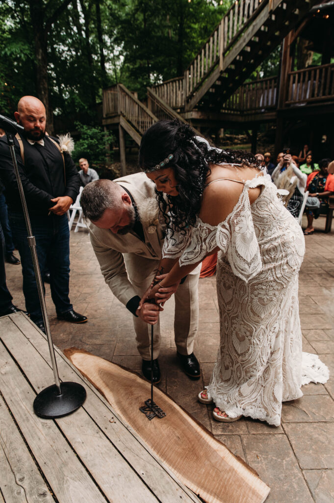 Bride and Groom brand a piece of wood at their ceremony at Mohican Treehouse Resort and Wedding Venue.