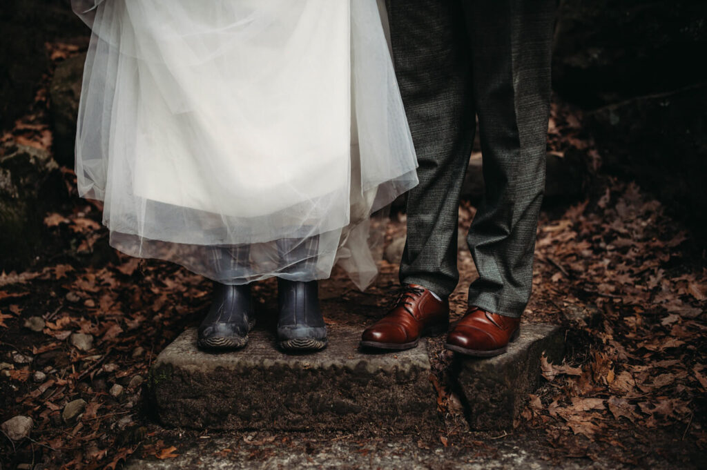 Couple wears hiking boots and dress shoes for elopement.