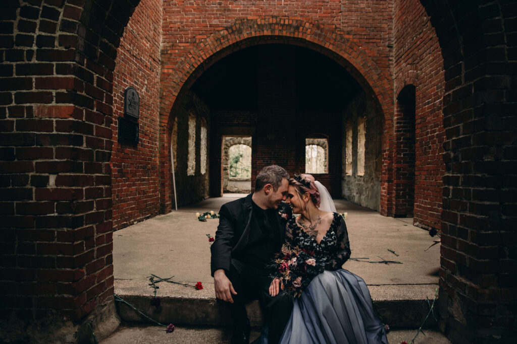 GOthic couple sit at Squires Castle in the interesting ceremony space.