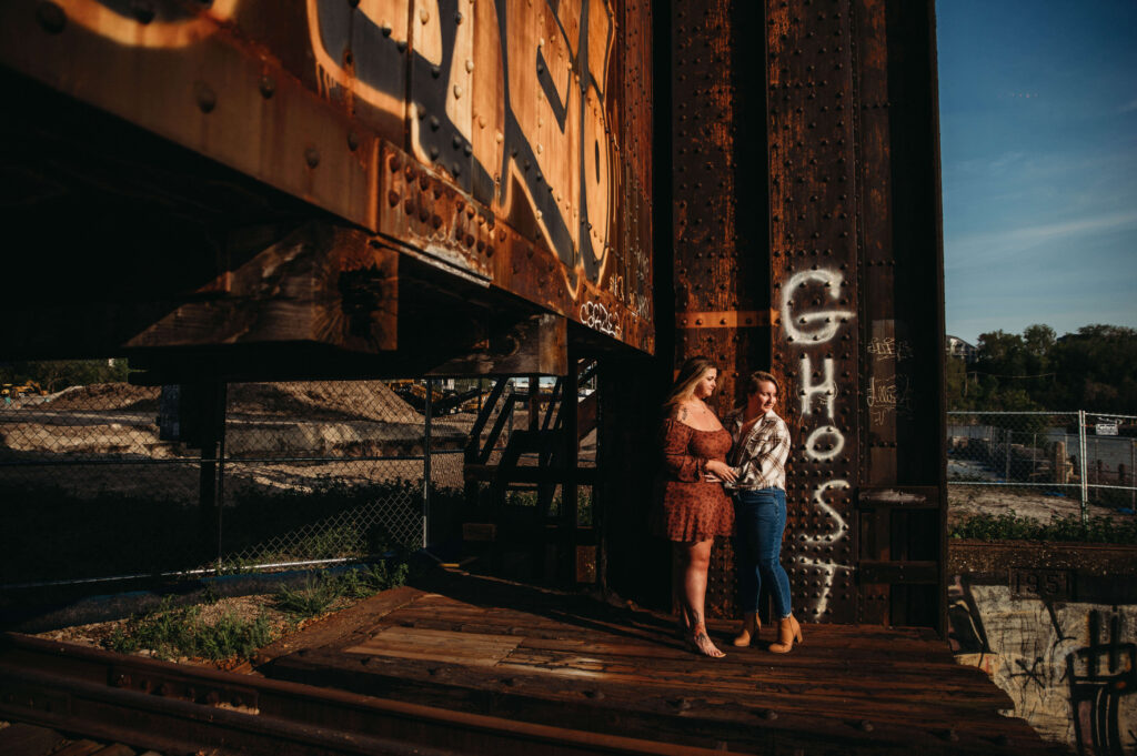 Industrial engagement image in the Flats with engaged LGBTQ couple.