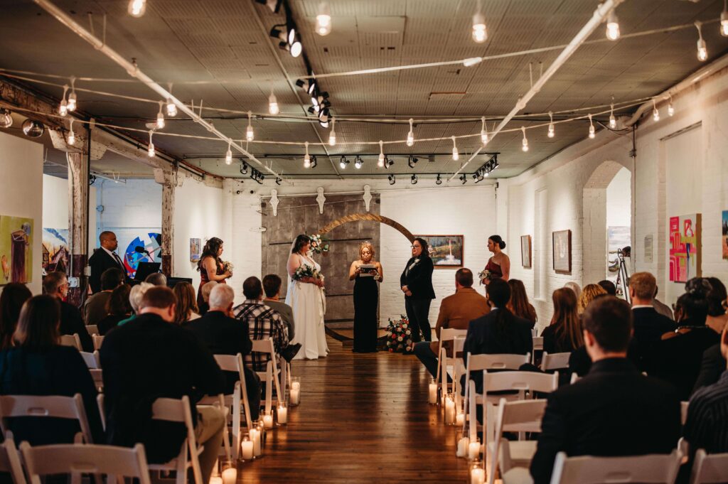 Intimate candlelit ceremony for two brides at Hedge Gallery.