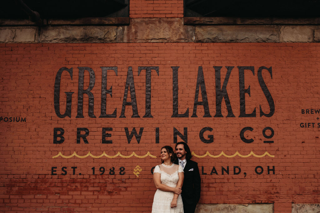 Couple stand in front of Great Lakes Mural in Ohio City during a summer reception.