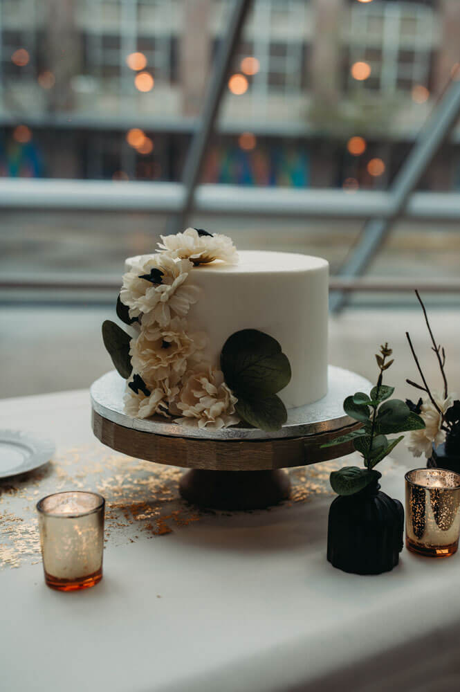 Simple and moody cake with black crows in the middle of flowers at Akron Art Museum.