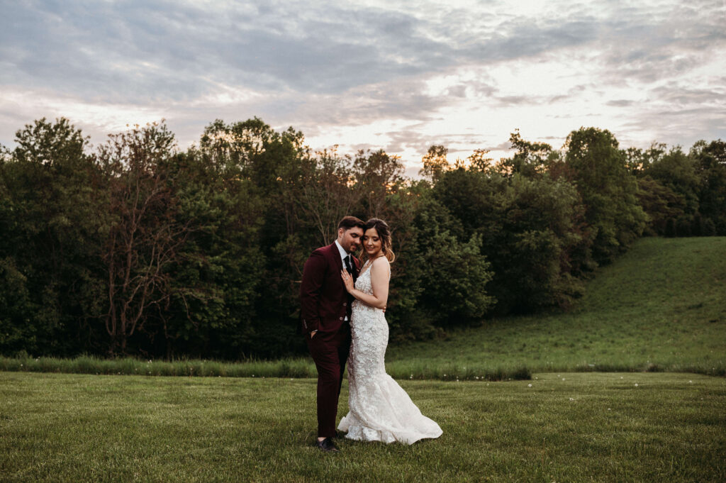 Bride and Groom cuddle up close as teh sun sets behind them on a spring wedding day in Ohio.