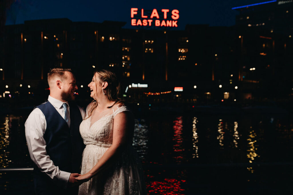 Night photo of newlyweds in front of Flats sign at Music Box.