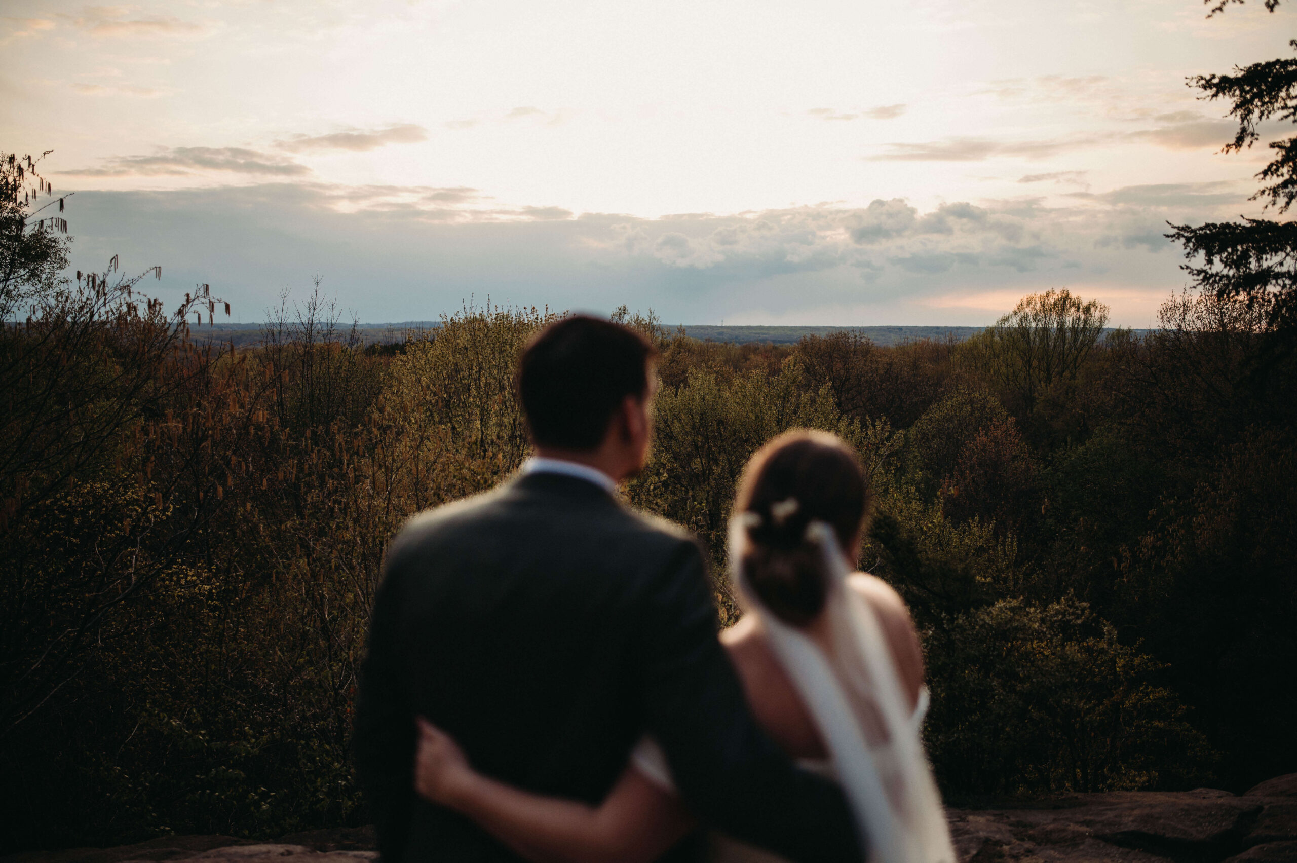 Eloped couple looks over sunset at Cuyahoga Valley National Park.