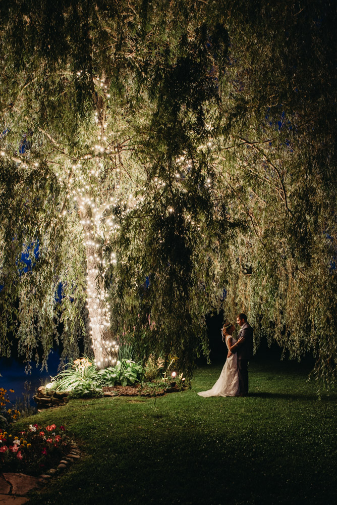 Night portrait in front of lit up willow tree at Meadow Ridge Events.