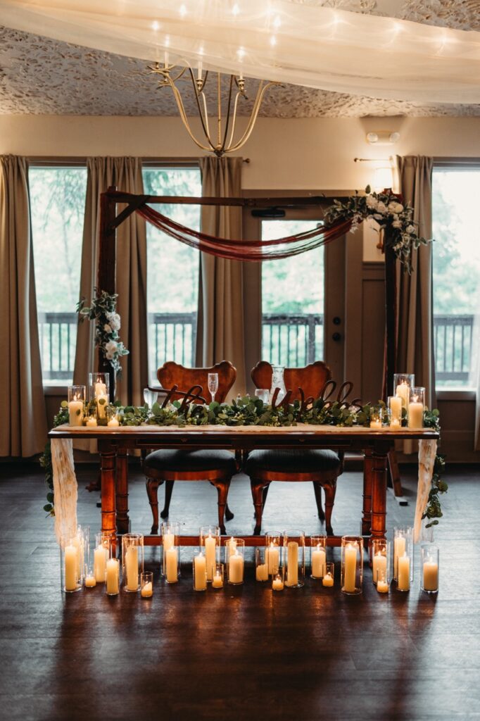 Inside reception hall, candles light up sweetheart table