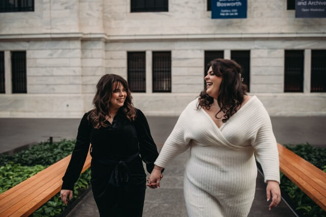 Couple walks in Cleveland Art Museum wearing black and white dresses.