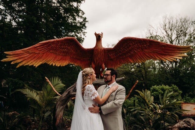 Newlyweds stand in front of Phoenix, Harry Potter's magical creature.