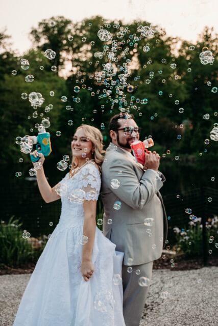 Newly married couple celebrate with bubble guns at reception