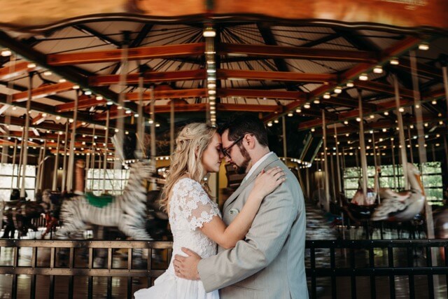 Wedding Couple stand in front of carousel at Cleveland Zoo wedding venue