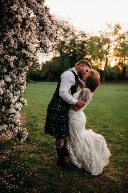 Couple kiss at sunset during Spring wedding at youngstown garden venue