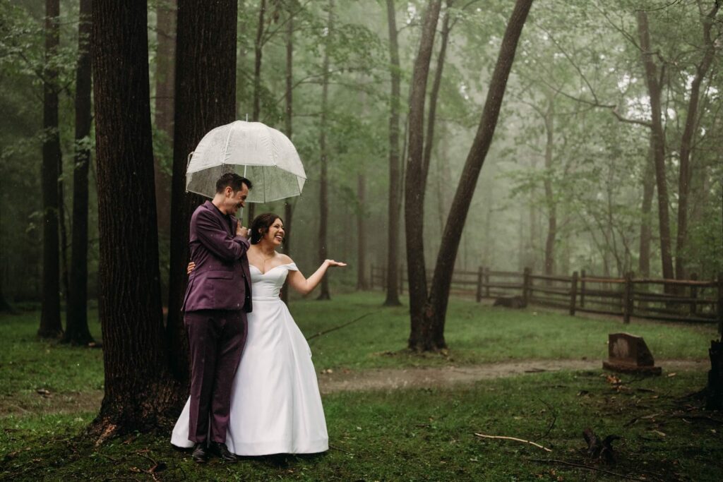 Couple stand in rain at cemetery behind happy days lodge wedding venue