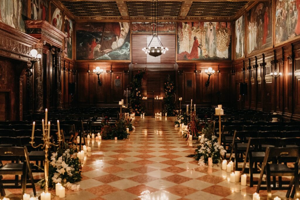 Abbey Room for winter wedding ceremony. Filled with candles and dark greenery floral.